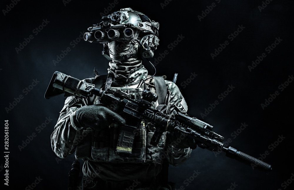 Modern combatant wearing night vision device black background