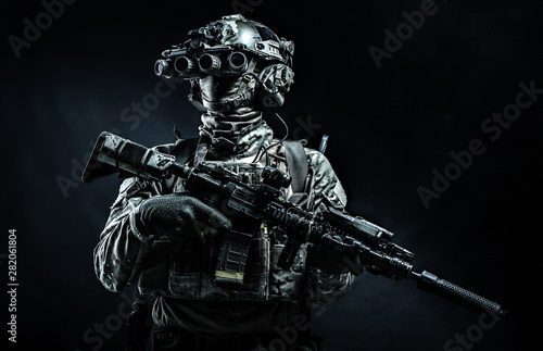 Modern combatant wearing night vision device black background