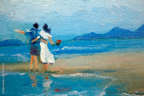 A couple in love a guy and a girl in a white dress with flowers in their hands on the beach. Painting on canvas