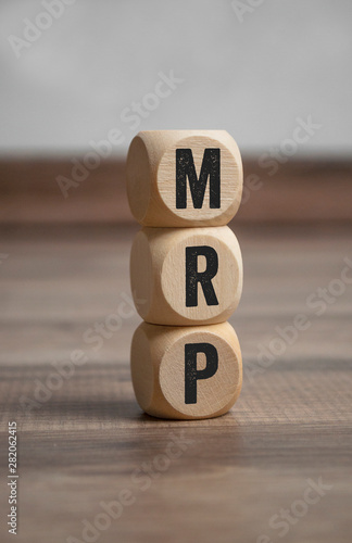 Cubes and dice with MRP Material Requirement Planning on wooden background photo