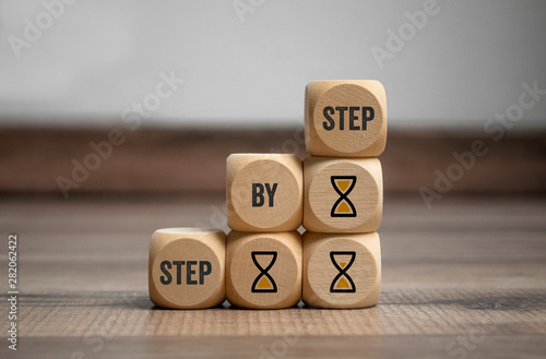 Cubes and dice with step by step on wooden background photo