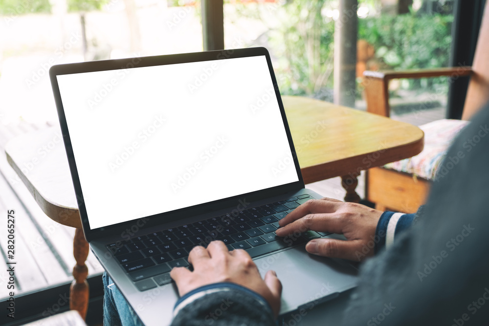 Mockup image of a woman using and typing on laptop keyboard with blank white desktop screen