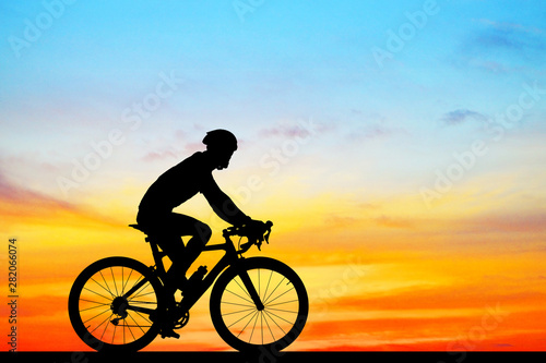 Fototapeta Naklejka Na Ścianę i Meble -  Silhouette  Cycling  on blurry sunrise  sky   background.