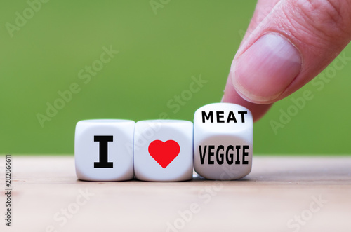 Hand turns a dice and changes the expression "I love veggie" to "I love meat".