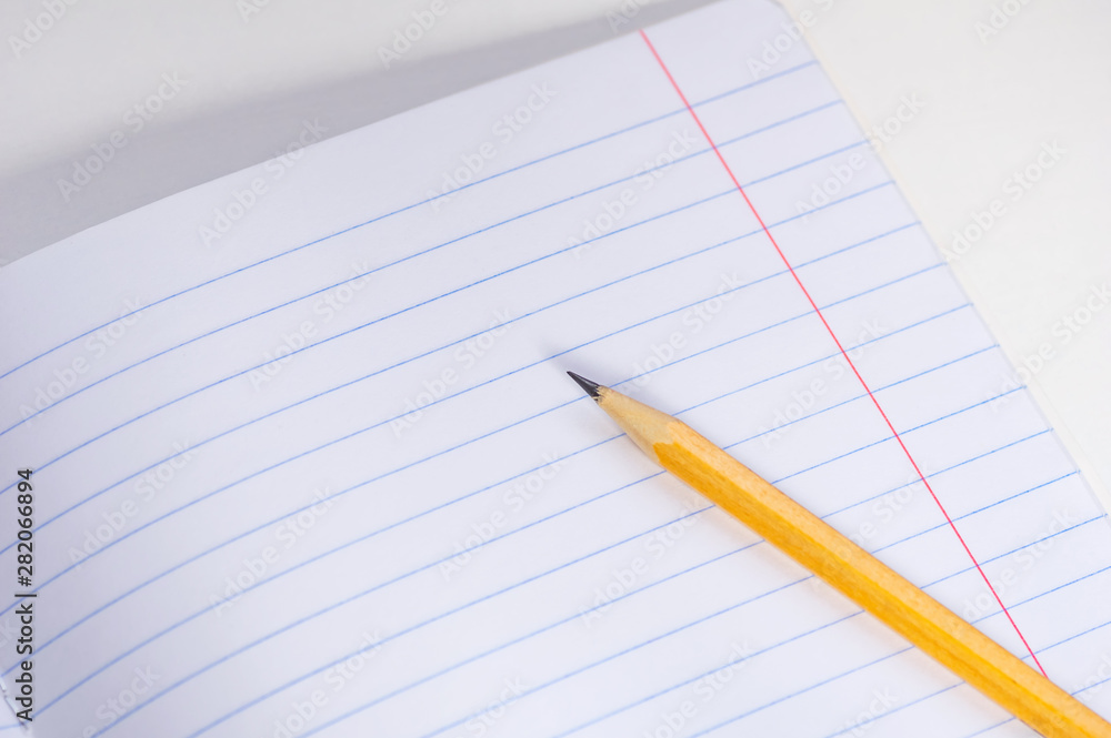 Back to school concept. School notebook and pencil on a light background. Back to school concept. School notebook and pencil on a light background.