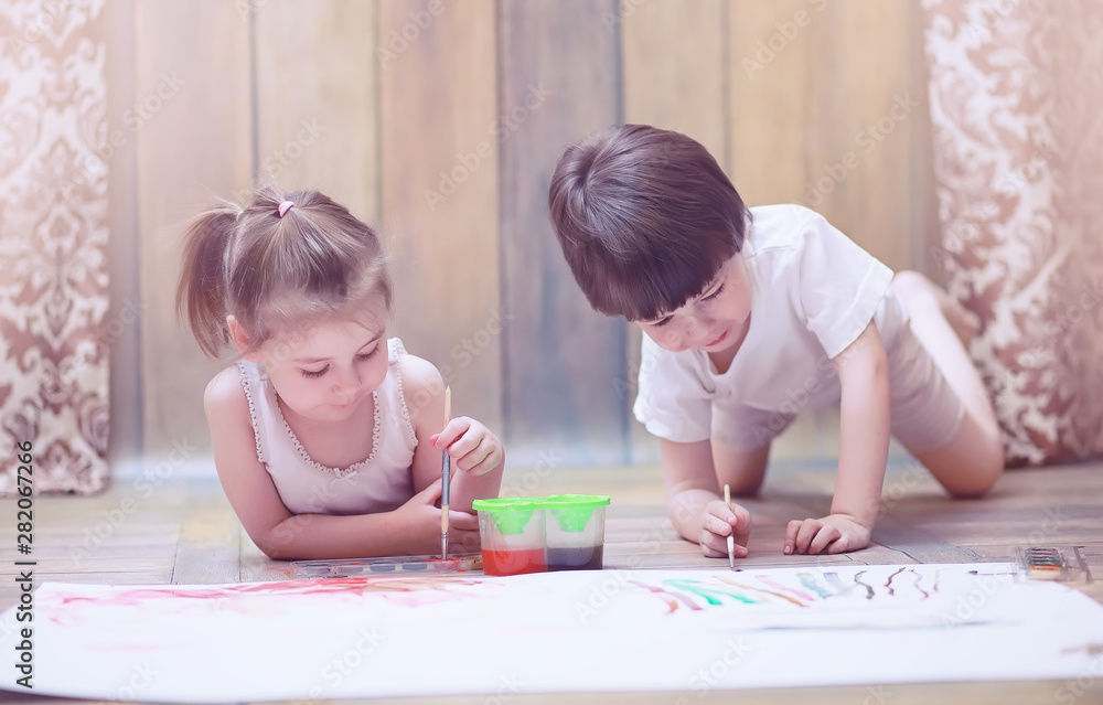 Little children paint on a large sheet of paper Little children paint on a large sheet of paper