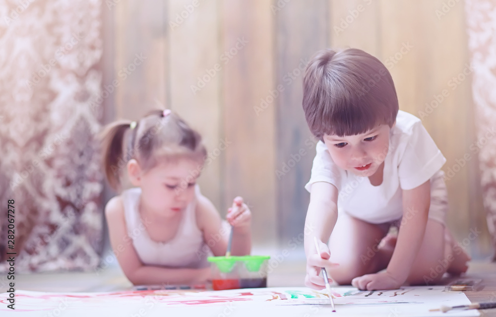Little children paint on a large sheet of paper Little children paint on a large sheet of paper