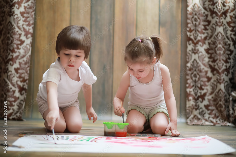 Little children paint on a large sheet of paper Little children paint on a large sheet of paper