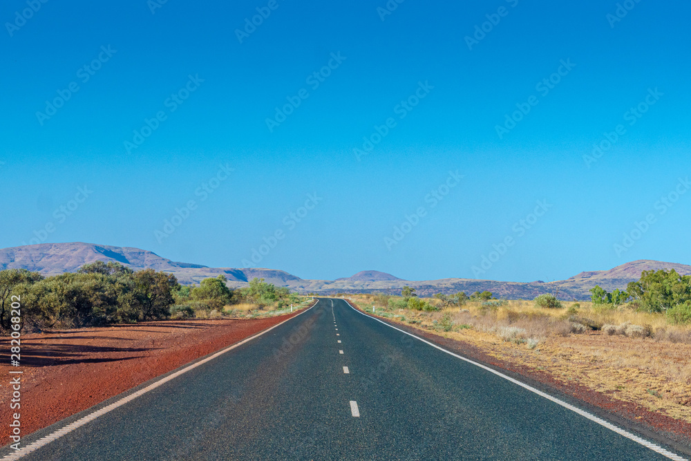Dark tarmac road in Australian Outback around Cheela Plains Karijini National Park