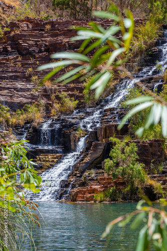Water rushing over natural steps of sediment rock at Fortescue Falls at the bottom of Dales Gorge Karijini National Park