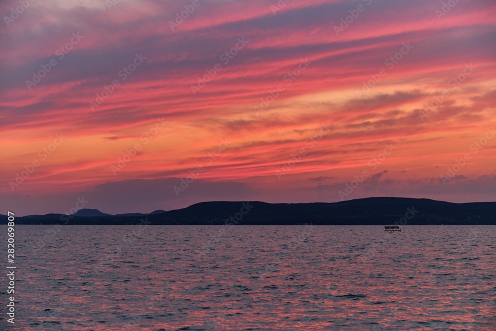 lake Balaton sunset pink and purple clouds, dark tones