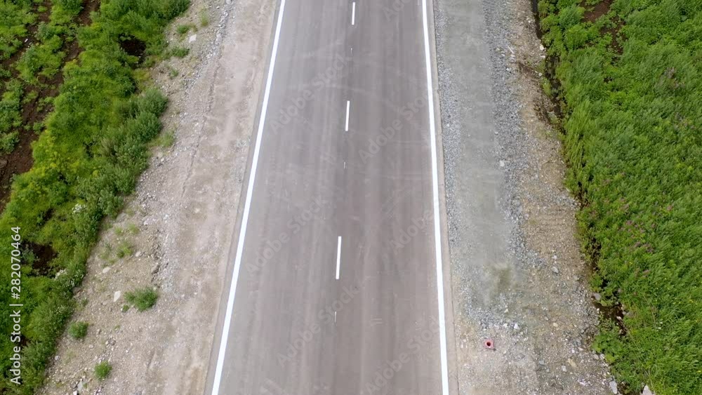 Aerial drone scene of route in steppe landscape at sunset golden hour. Camera moving forward following tracked van on the road. Aerial drone scene of route in steppe landscape at sunset golden hour. Camera moving forward following tracked van on the road.