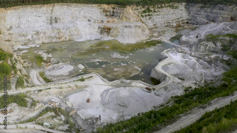 Aerial view of opencast mining quarry with lots of machinery at work - view from above. 4K footage from drone Aerial view of opencast mining quarry with lots of machinery at work - view from above. 4K footage from drone