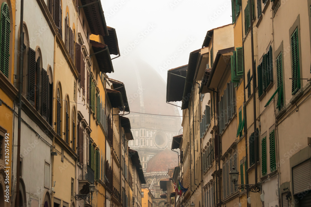 Florence street view with the Duomo (Santa Maria del Fiore) at the background in heavy mist