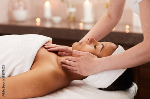 Side view portrait of beautiful mixed-race woman enjoying massage in luxury SPA  copy space