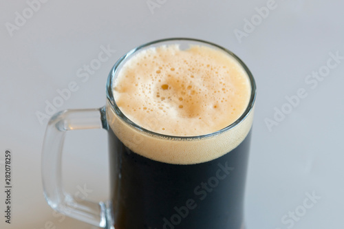 Glass of dark beer on a gray background