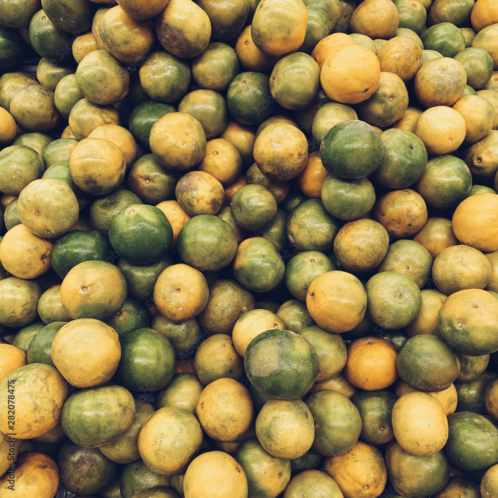 A great amount of green and yellow limes. Vegetarian, vegan, healthy and summer concept. Natural sunny juicy background, pattern and texture. Top view, flat lay.