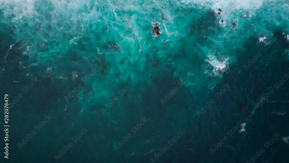 Top view of the ocean surface near the rocky coast off the island of Tenenife, Canary Islands, Spain. Aerial drone footage of sea waves reaching shore Top view of the ocean surface near the rocky coast off the island of Tenenife, Canary Islands, Spain. Aerial drone footage of sea waves reaching shore