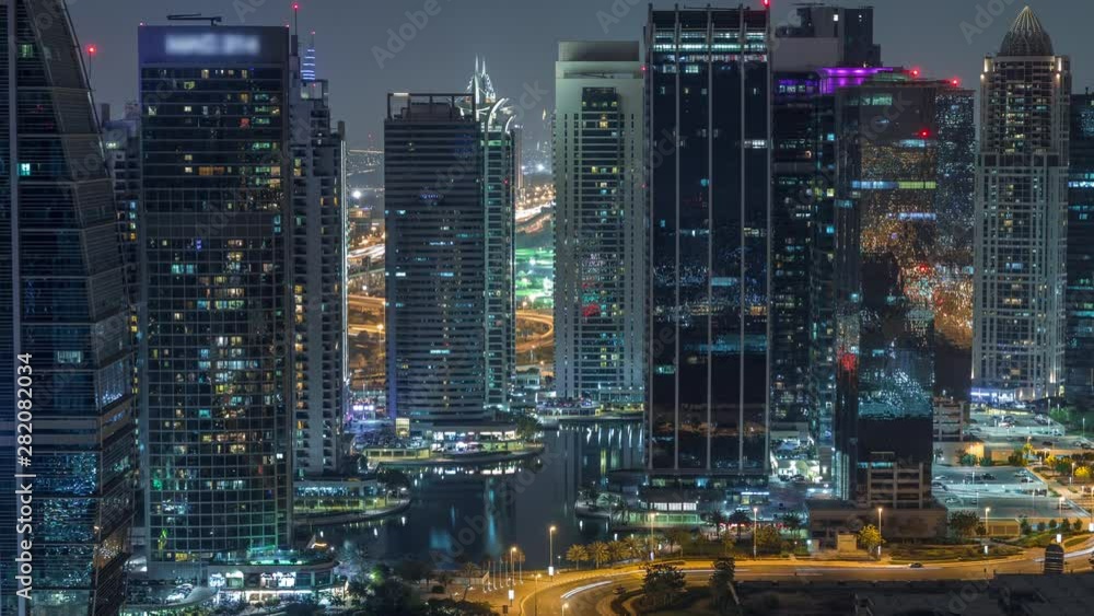 Jumeirah Lake Towers residential district aerial night timelapse near Dubai Marina. Illuminated modern skyscrapers and traffic from above Jumeirah Lake Towers residential district aerial night timelapse near Dubai Marina. Illuminated modern skyscrapers and traffic from above