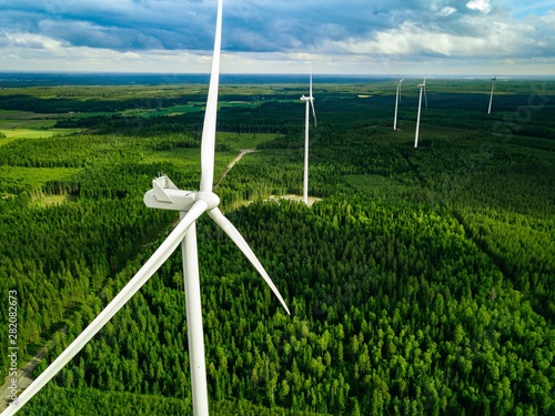 Aerial view of windmills in summer forest in Finland. Wind turbines for electric power with clean and Renewable Energy