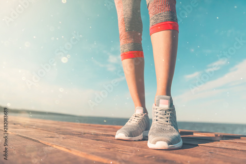 Legs in sneakers close-up. Health and Yoga Concept. Rear view close up strong athletic female legs and running shoes of sport. Sporty young girl practicing yoga. Woman do gymnastics outdoors