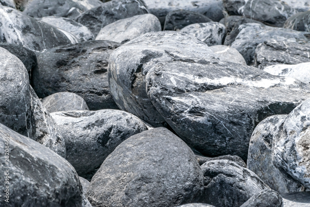 Gray and white large pebbles stone pile background. Natural environmental decorative material. Stone fence or wall Gray and white large pebbles stone pile background. Natural environmental decorative material. Stone fence or wall