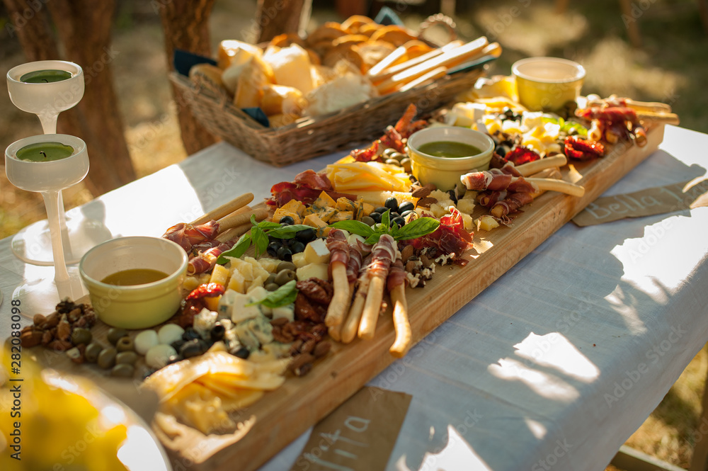 Reception. Board with snacks. Various cheeses, jamon, grissini