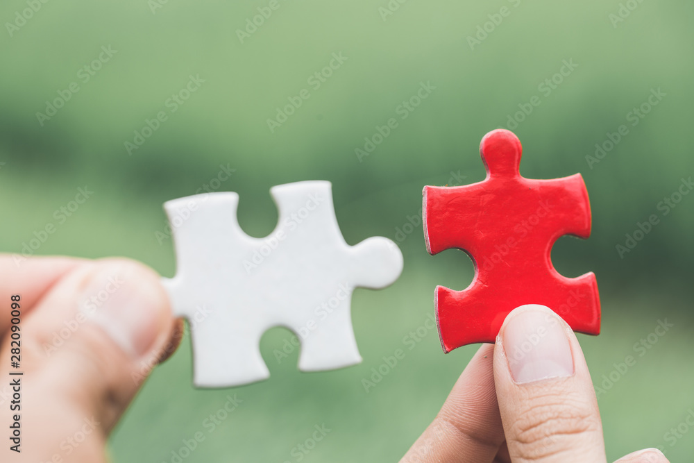 Business woman is trying to connect couple puzzle piece. Symbol of association and connection. Concept of business strategy Business woman is trying to connect couple puzzle piece. Symbol of association and connection. Concept of business strategy