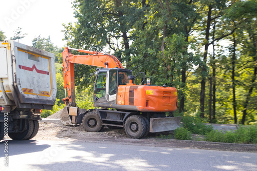 Orange excavator on wheels, earthmoving machinery for construction and earthworks