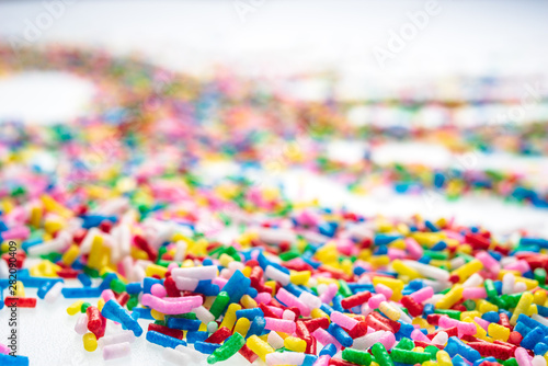Colorful candy sprinkles close up for birthday cake on white background © Liran