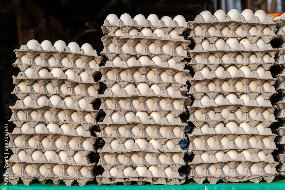 Stacks of white eggs in trays on local street market in India