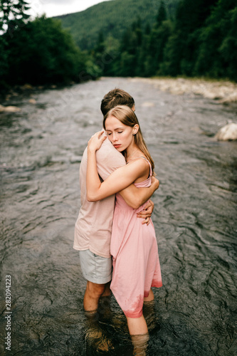Lifestyle loving couple hugging in the river