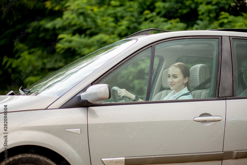 Pretty, young woman driving a car -Invitation to travel. Car rental or vacation