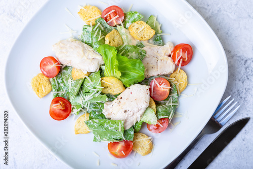 Caesar (cesar) salad with chicken, crackers, parmesan and cherry tomatoes. Close-up.