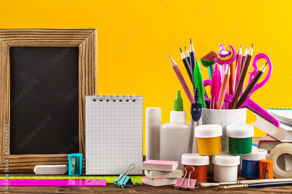 Stationery on a table in front of blackboard. Stationery on a table in front of blackboard.