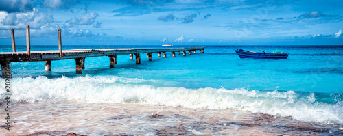Fishing boat at the sea coast of the Dominican Republic. Blue fishing boat. Panoramic view of the tropical beach in Dominican Republic.