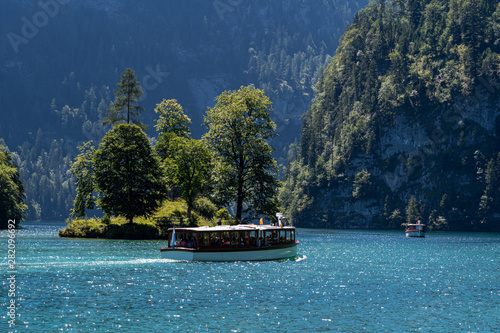 View of Konigssee with the island and passenger boat from Schonau in Bavaria, Germany, Europe in the summer of 2019 photo