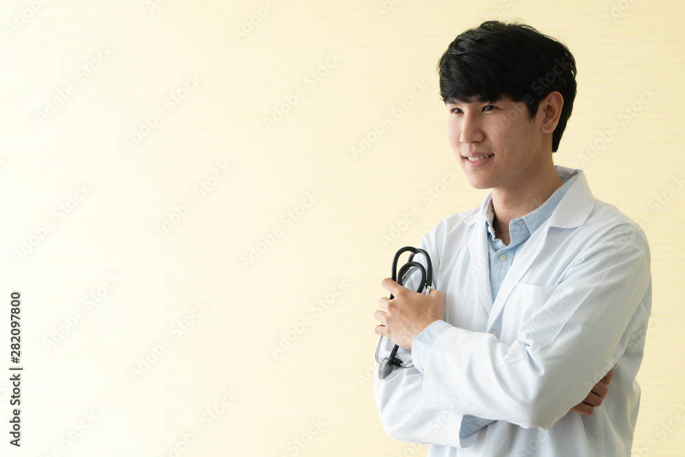 Portrait of Asian young doctor with arms crossed holding stethoscope in  hospital emergency lap. Concept of healthcare patient lifestyle and medical.