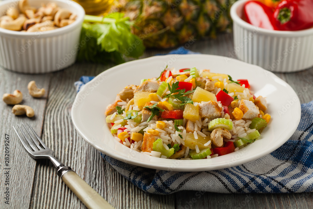 Salad with rice, chicken, peanuts and vegetables. Front view.