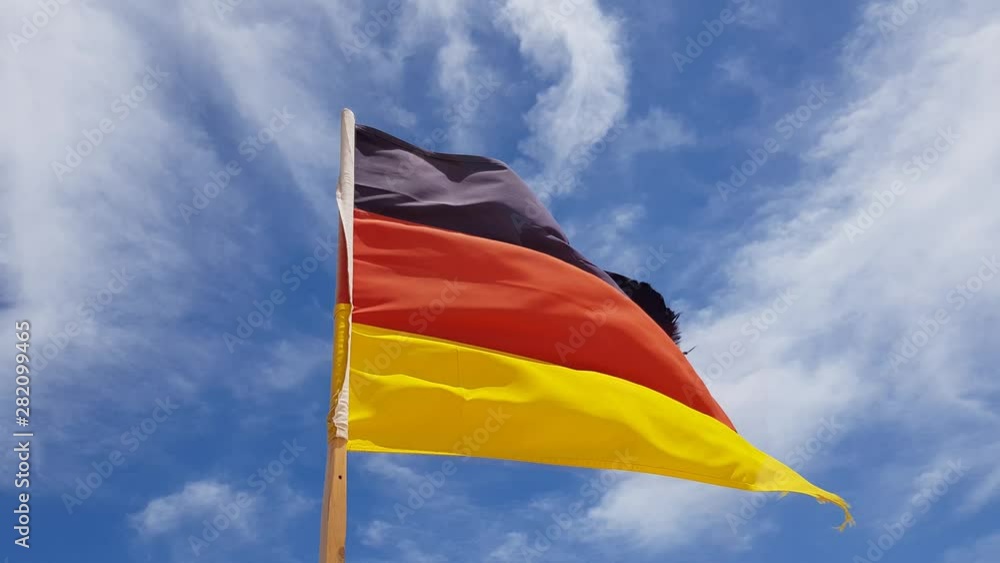 old germany flag with ragged edge on sky background old germany flag with ragged edge on sky background