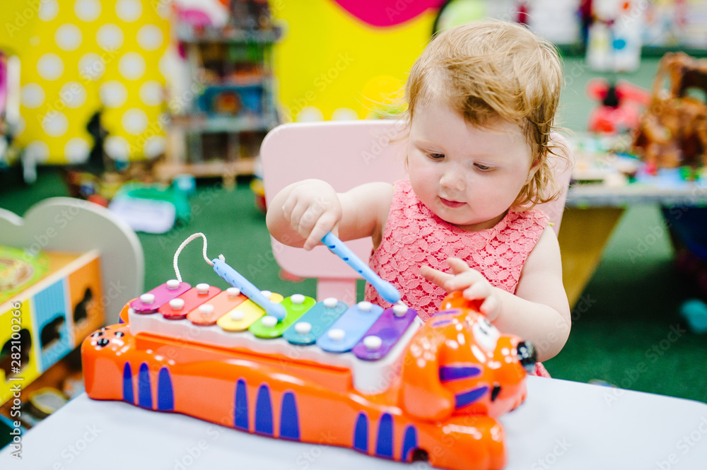 Happy little kid baby girl 1 2 years children plays a musical instrument xylophone in game center amusement of the children s room for birthday. indoor entertainment. Stock Foto Adobe Stock