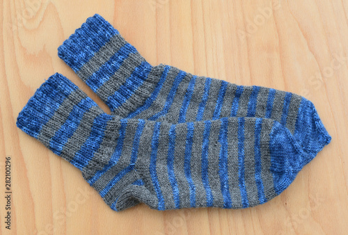 Background feet gray and blue knit a pair of sheep socks thick warm white winter wool.