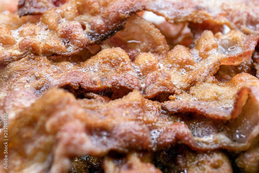 Cooked, appetizing bacon rashers on plate, closeup Cooked, appetizing bacon rashers on plate, closeup