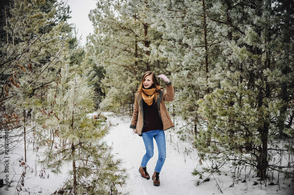 Outdoor close up portrait of young beautiful happy smiling girl wearing scarf and gloves in forest. Model posing in a snowy park. Winter holidays concept. Frost winter walks season. Outdoor close up portrait of young beautiful happy smiling girl wearing scarf and gloves in forest. Model posing in a snowy park. Winter holidays concept. Frost winter walks season.