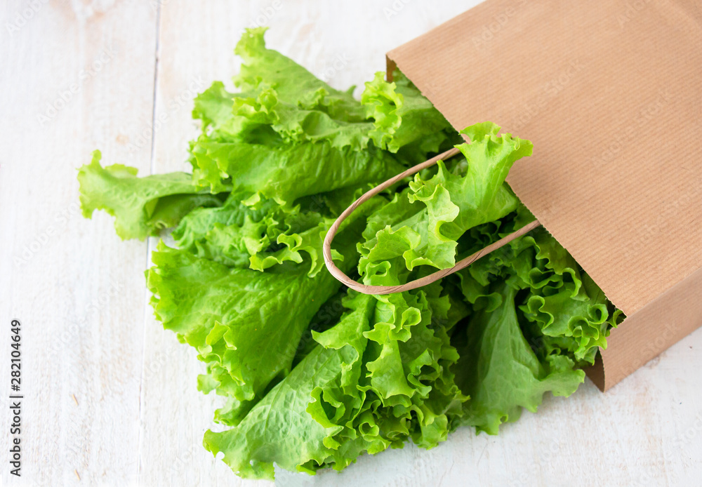 fresh green salad in beige paper ecological packaging, top view fresh green salad in beige paper ecological packaging, top view