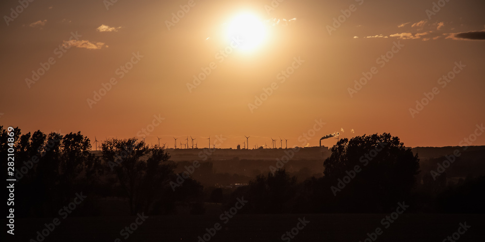 Wind turbines on the horizon as the sun goes down Wind turbines on the horizon as the sun goes down