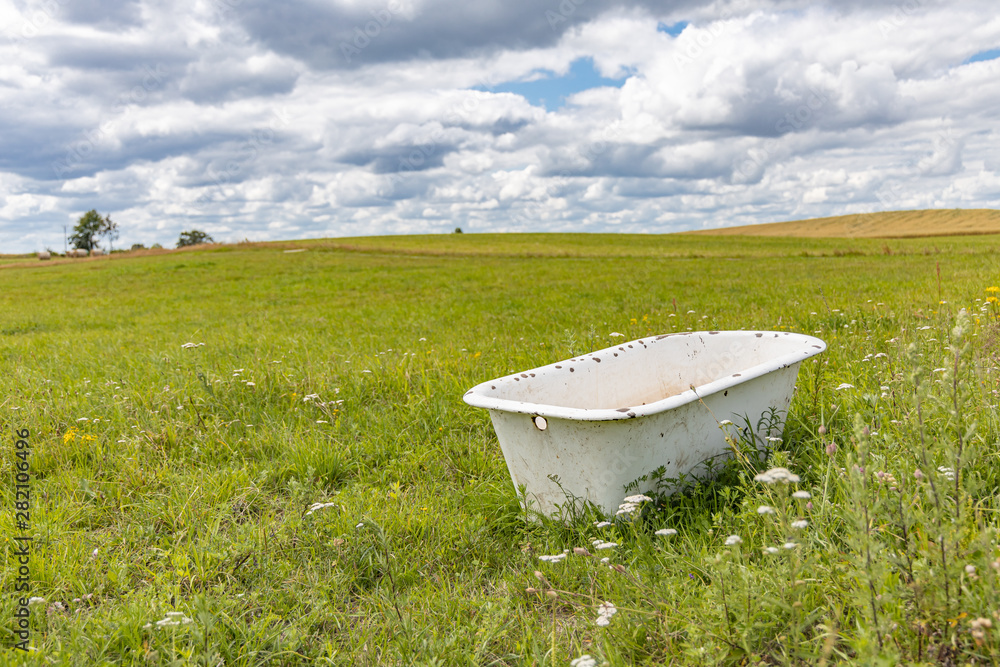 Old bath tube in the middle of the meadow.