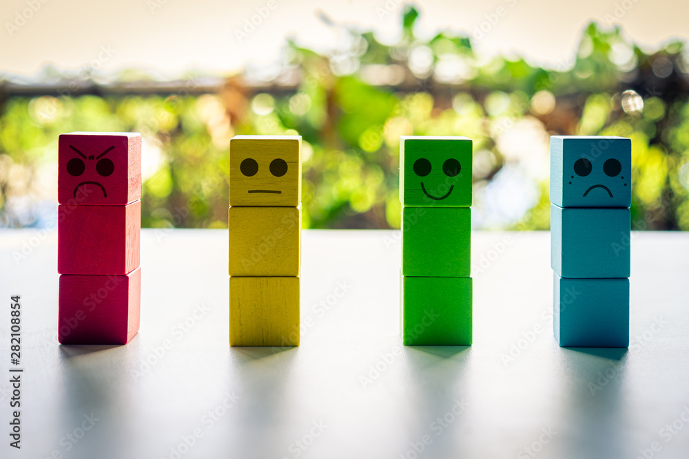 Four colorful block with different emotions on nature background, Customer satisfaction survey concept. Four colorful block with different emotions on nature background, Customer satisfaction survey concept.