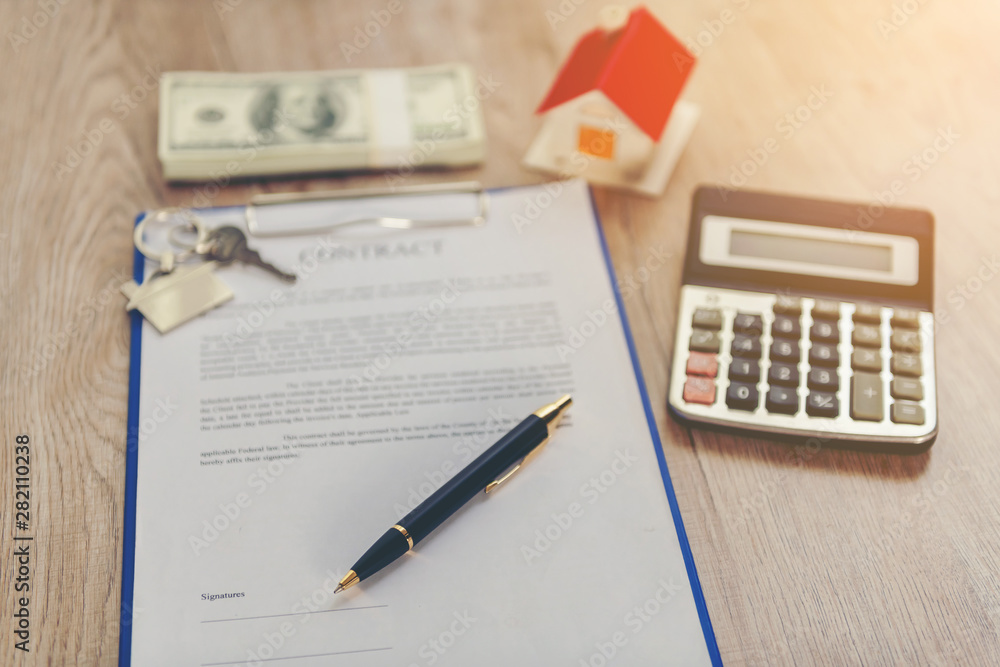 Real estate broker sale contract for house resale agreement with ink pen and house keys on a Realtor key holder lock box (fictitious document with authentic legal language)