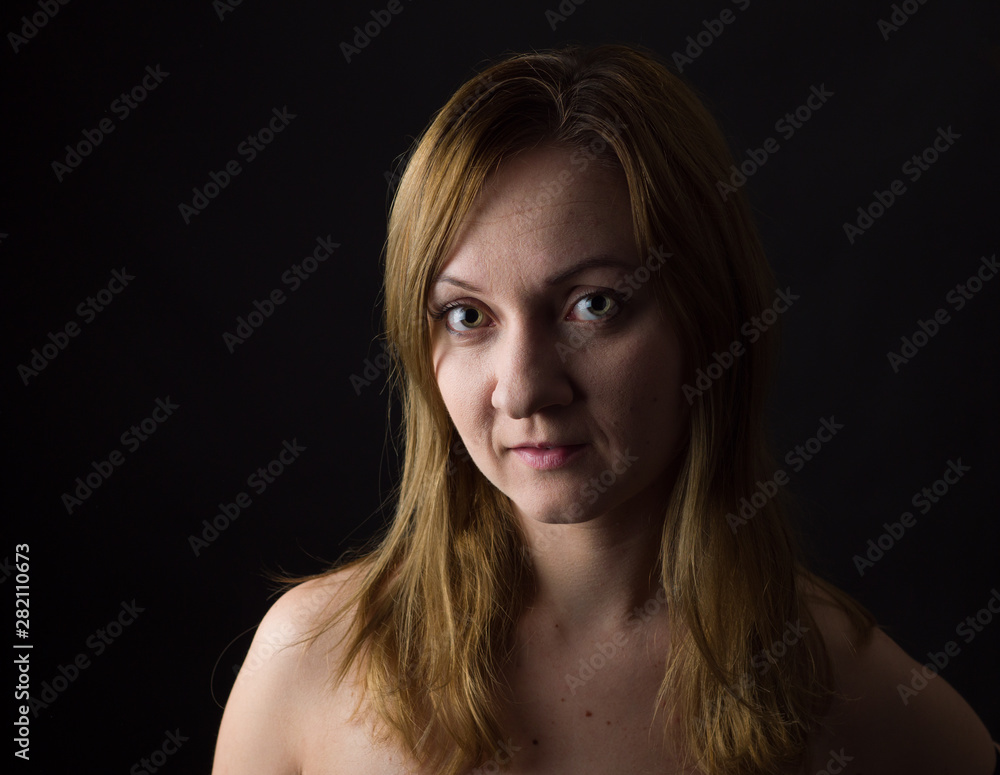 Naklejka premium portrait of young woman, no make up, low key, brown dark hair, natural looking making expressions 